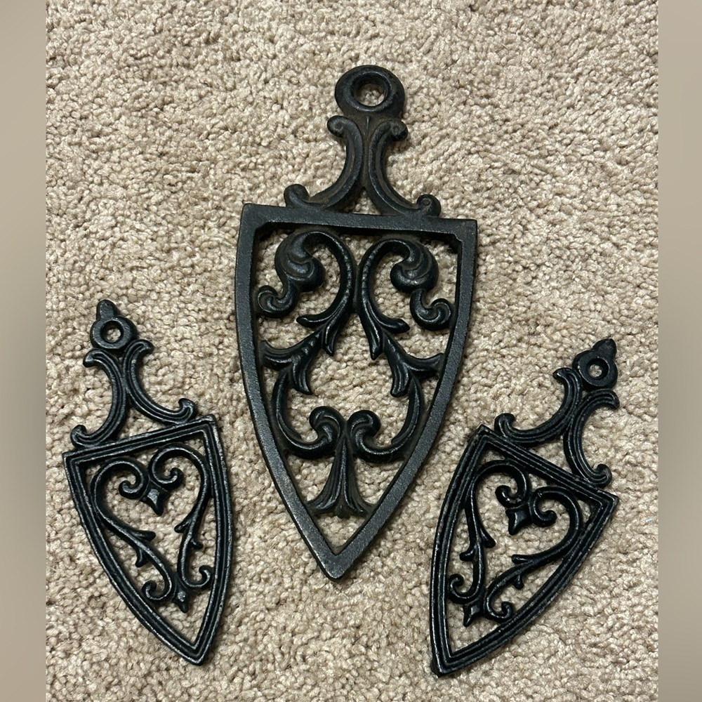 Three black cast iron trivets